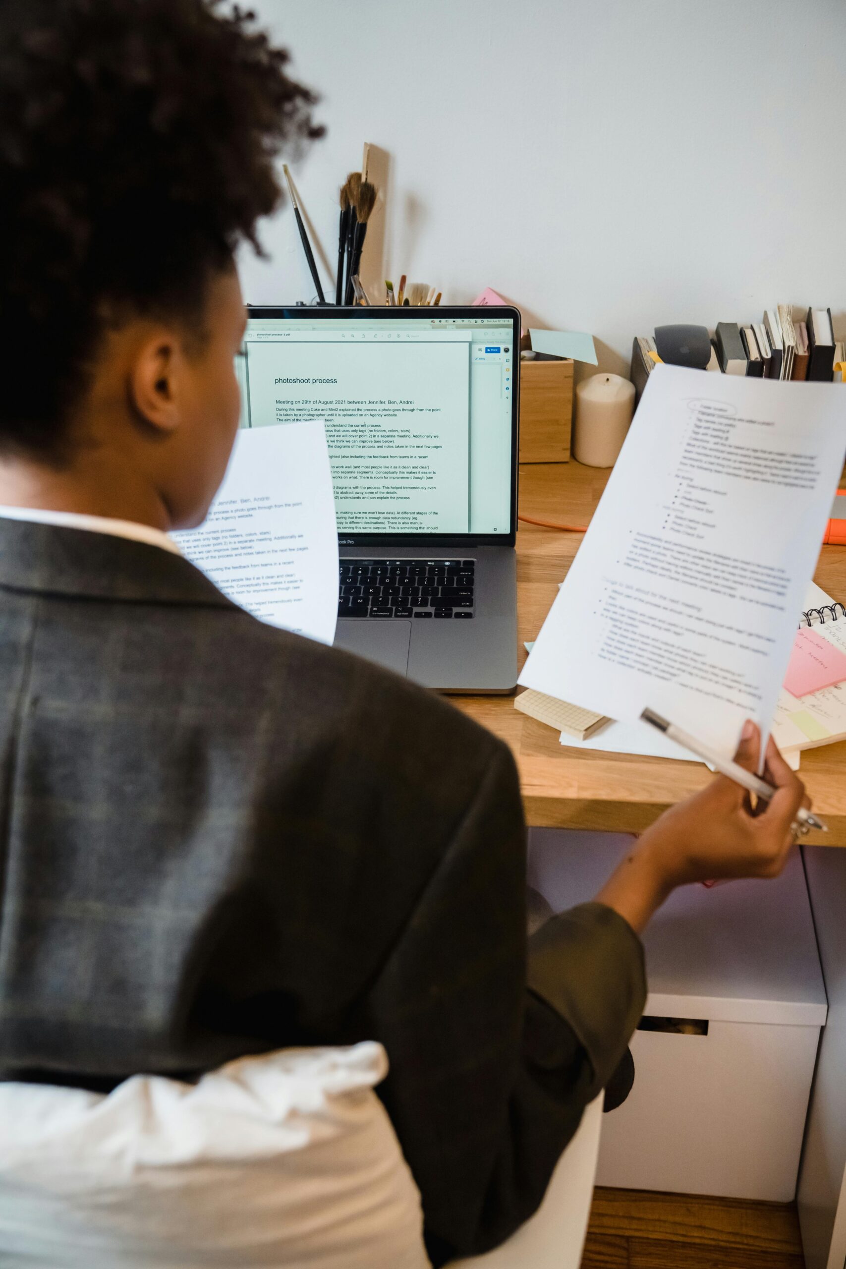 A businesswoman in an office setting carefully reading and analyzing important documents.